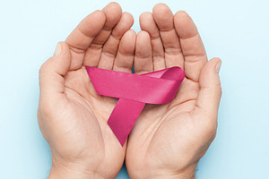 Male hands holding a pink ribbon, symbol of breast cancer awaren, a Person Photo by ndanko