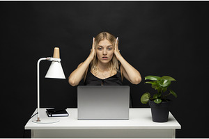 Shocked young woman at desk with, a Business Photo by volodymyrshtun13795