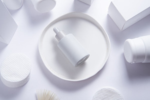 Top view of cosmetic serum bottle on white tray with skincare pr, an Industrial Photo by MDBildes