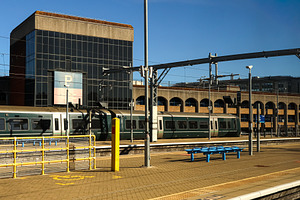 Train standing at a platform in a modern city railway station bu, a Photo by Studio ANNA