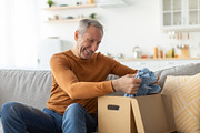 Happy mature man unpacking parcel after online shopping, a Photo by Prostock-Studio (Thumbnail 1 of 2)