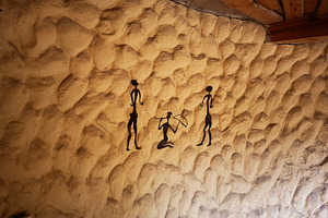 Primitive style artwork depicting historic figures on a rustic textured wall, a Photo by AS photostudio
