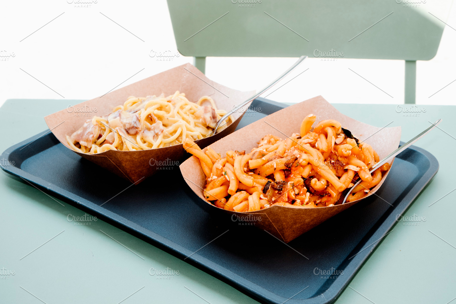 two pasta servings on an outdoor table, a Photo by Nito