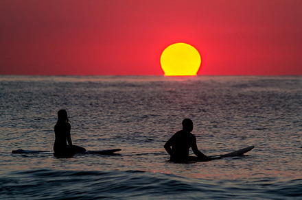 Ocean city containing sunrise, surfer, and surfers