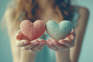 Happy young woman holds in hands love hearts, a Photo by AlyaAnd