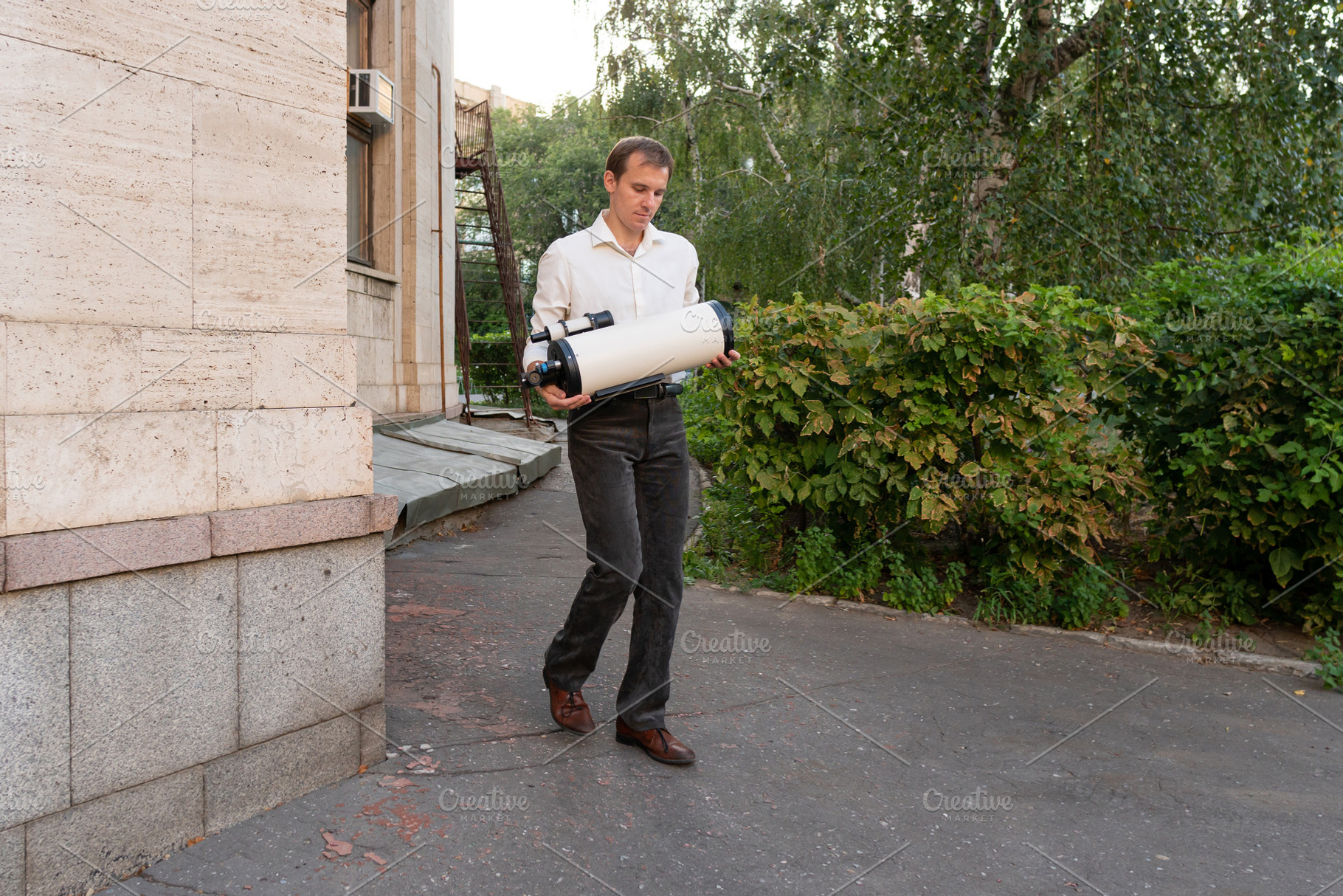 Man carrying large white telescope, a School & Education Photo by Elena Vagengeim