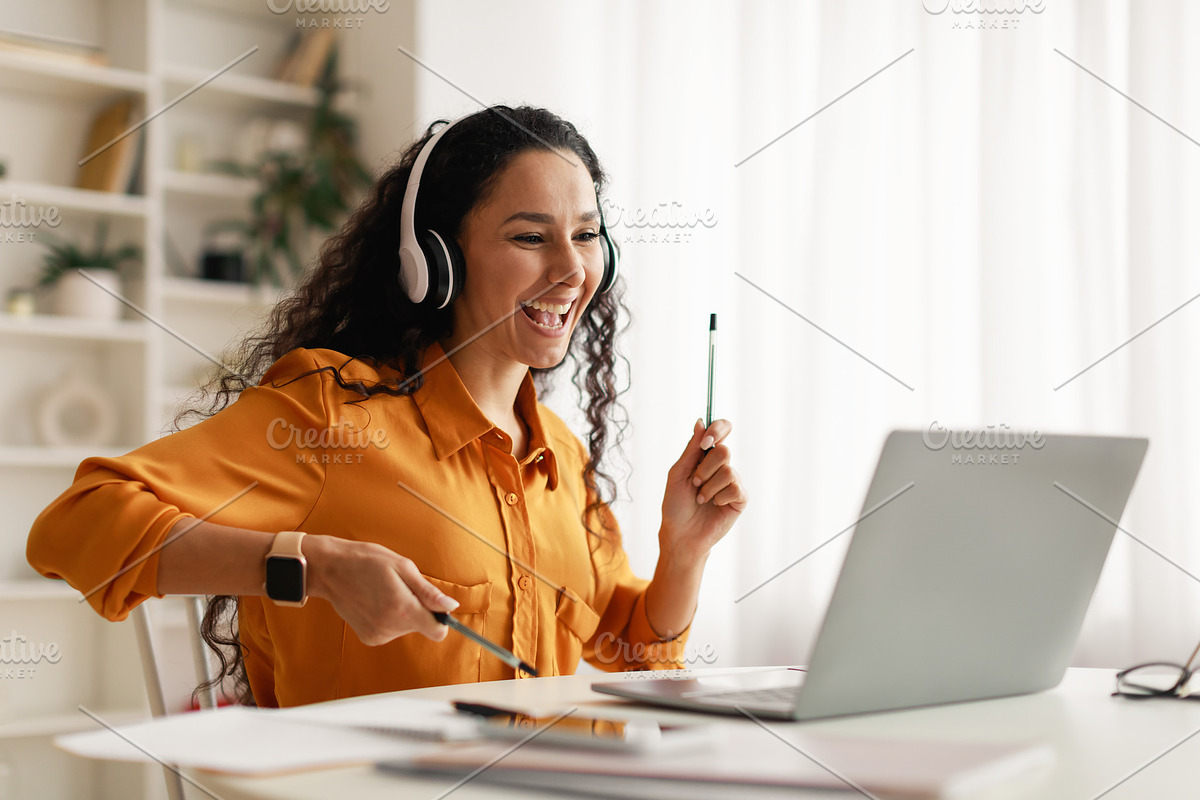 Middle Eastern Woman Listening Music Using Laptop Having Fun Indoors, a Photo by Prostock-Studio (Photo 3 of 5)