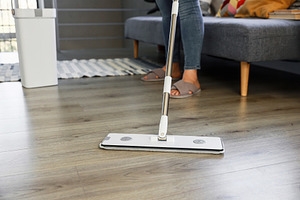 Woman mopping, wiping floor in home setting. Housewife uses mop, plastic bucket, a Person Photo by Lenor4ik