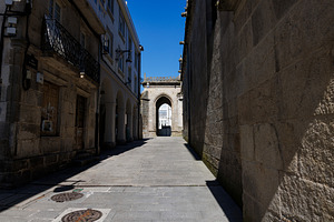 Narrow sunlit cobblestone alley leading to the cathedral entrance in Lugo Spain, an Architecture Photo by Bepslabor