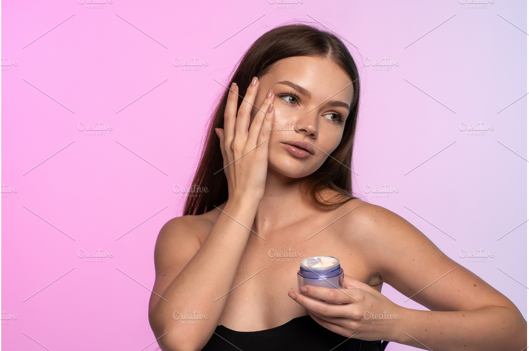 Young woman applying face cream, a Beauty & Fashion Photo by volodymyrshtun13795