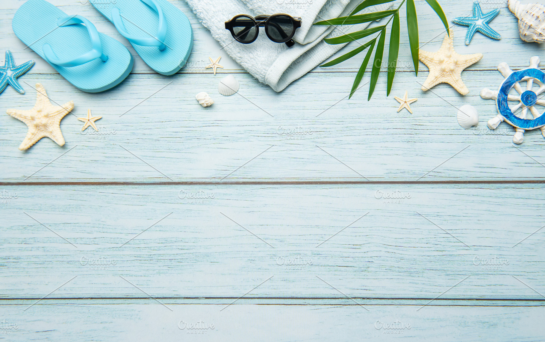 Summer accessories creating a frame on light blue wooden backgro, a Holiday Photo by Olena Rudo