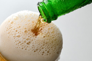 Filling glass with sparkling drink from green bottle, a Food & Drink Photo by Davizro's Market