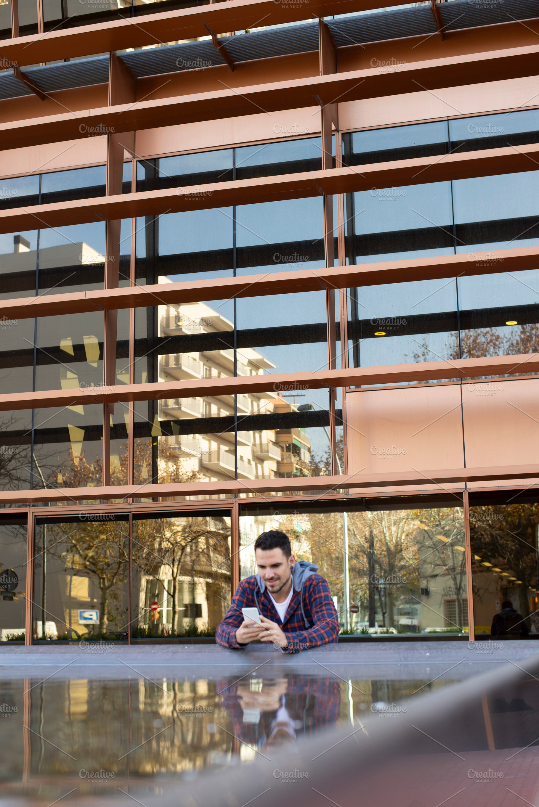 Caucasian man using smartphone in front of modern office, a Person Photo by RF Images