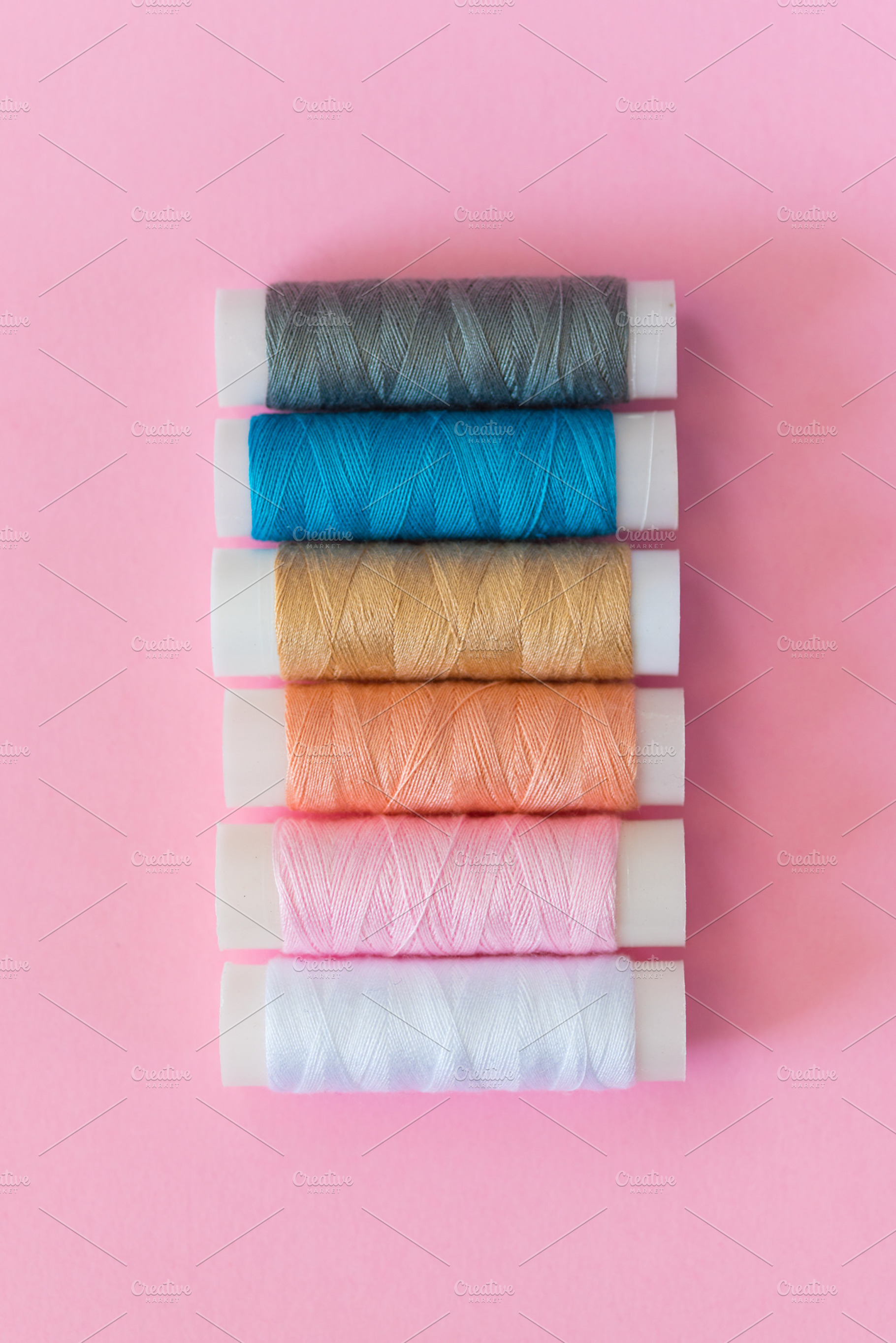 Thread spools with pink background featuring thread, spool, and embroidery, an Arts & Entertainment Photo by Ekaterina Tarasenko