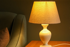 Cozy table lamp illuminating bedroom nightstand, creating warm ambiance for rel, a Photo by Studio ANNA