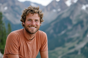 Smiling man enjoying the outdoors with mountains in the backgrou, a Person Photo by AlyaAnd
