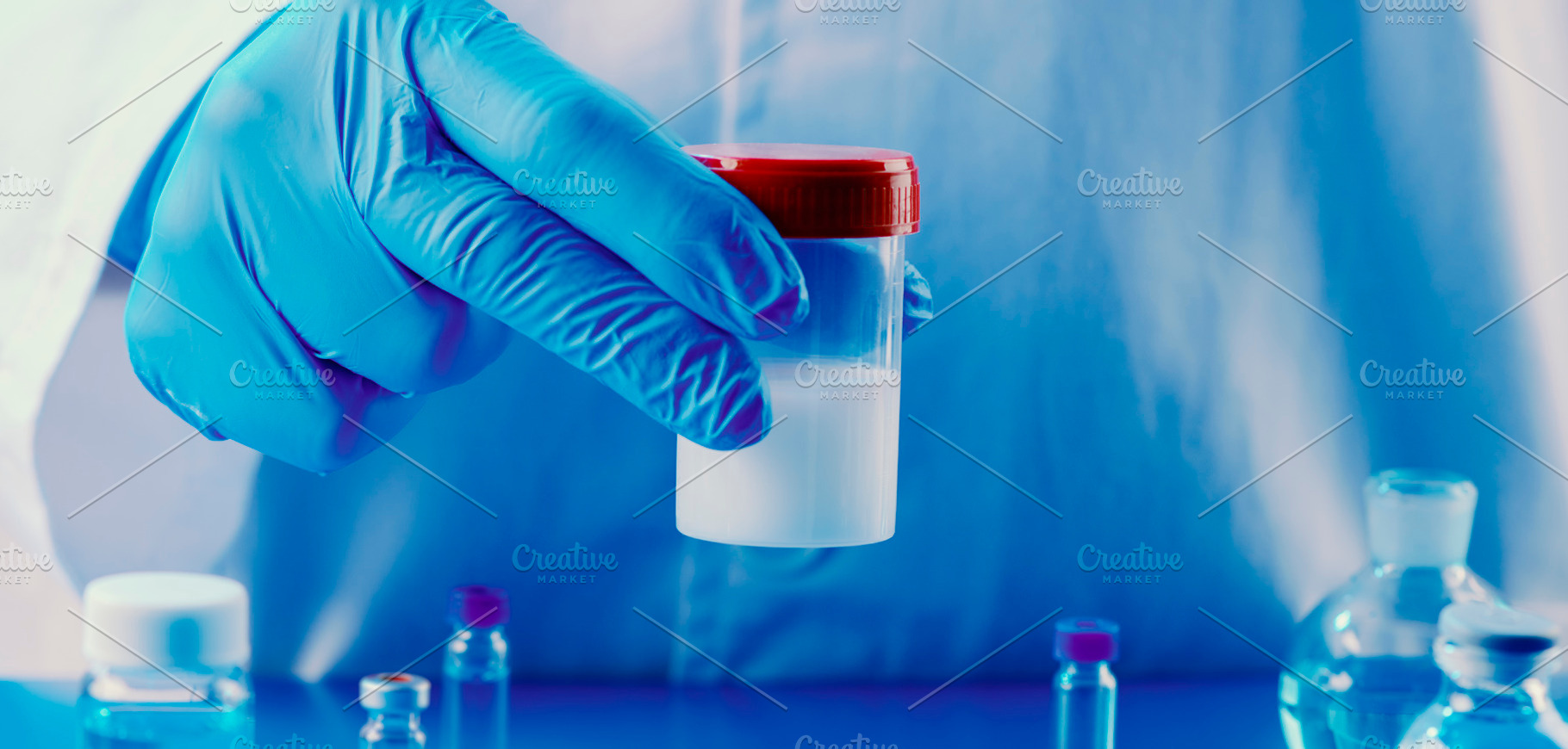 lab worker holds a container with semen, banner, a Photo by Nito