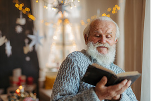 Old man reading from bible during, a Person Photo by HalfPoint