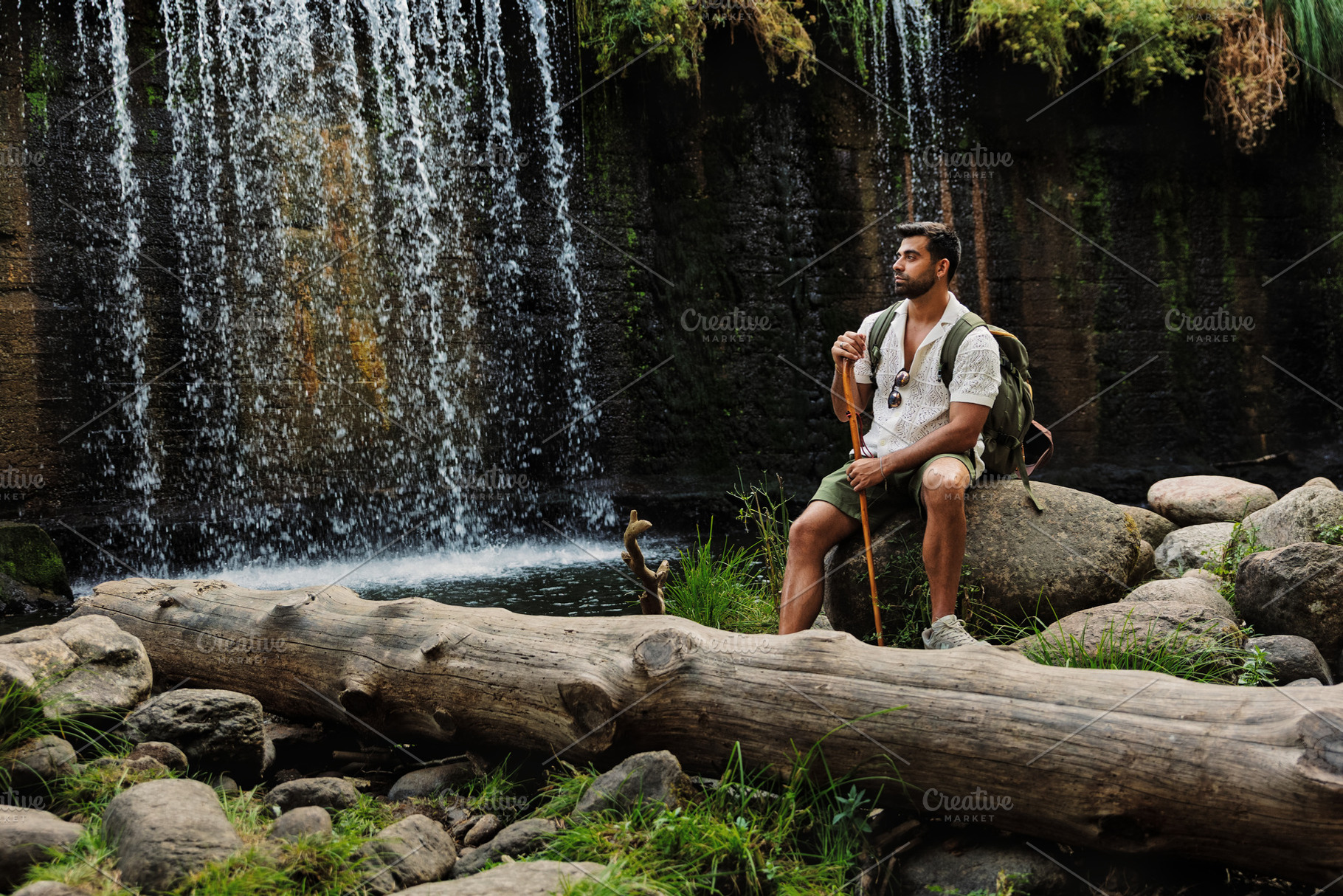 Hiker resting on a rock next to a wa, a Person Photo by Perpis