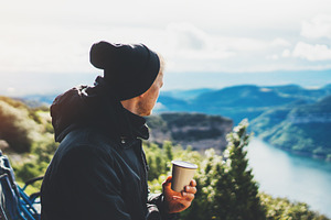 A cup of hot coffee in nature stock photo containing hands and holding