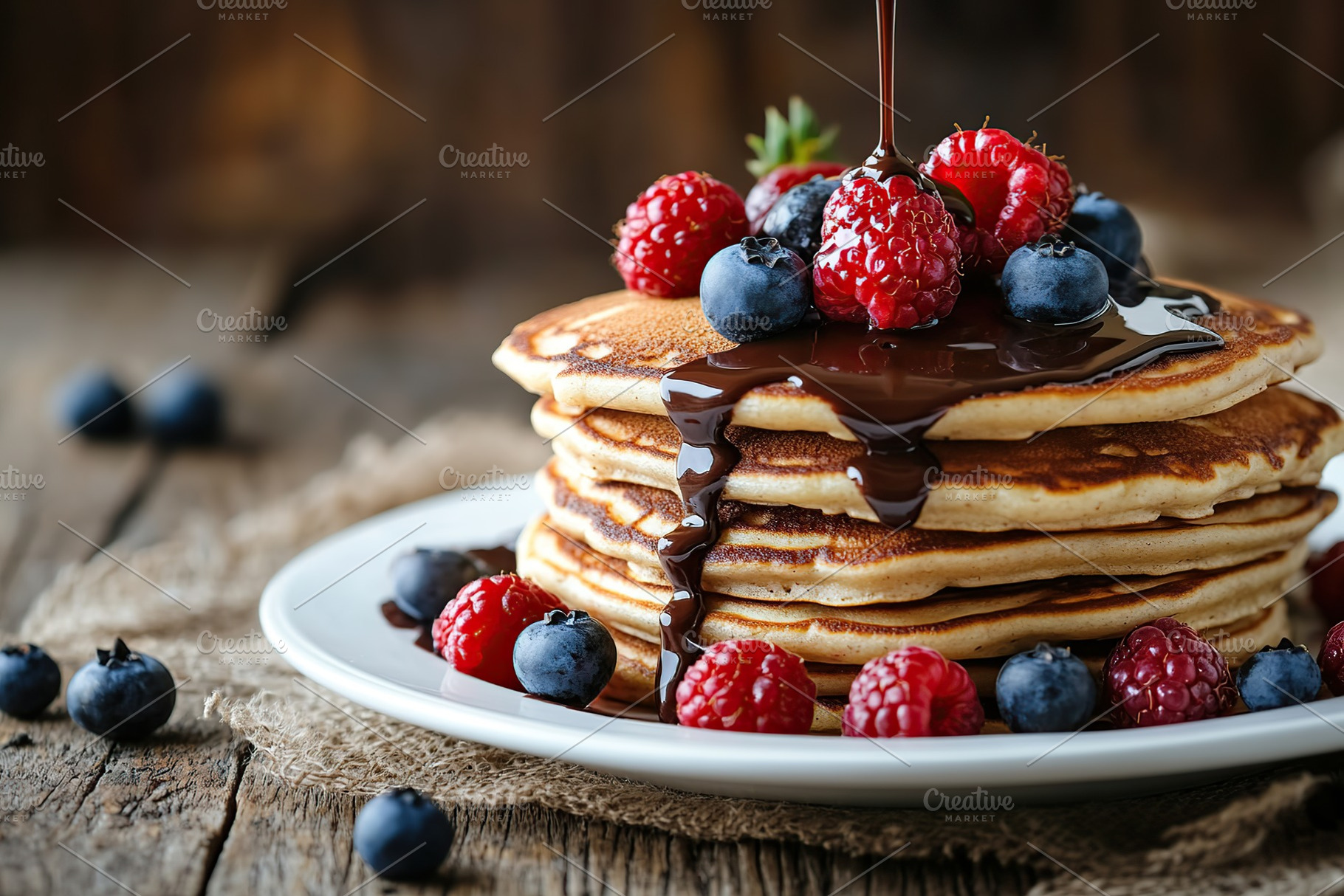 Delicious pancakes topped with fresh berries and melted chocolate sauce on a ru, a Food & Drink Photo by AlyaAnd