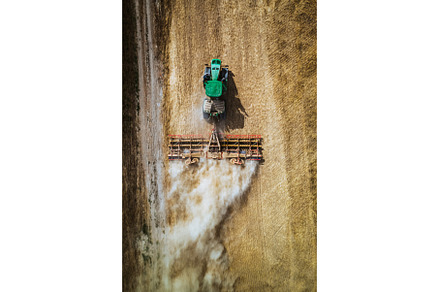 Aerial view of a harvester working, an Industrial Photo by HalfPoint