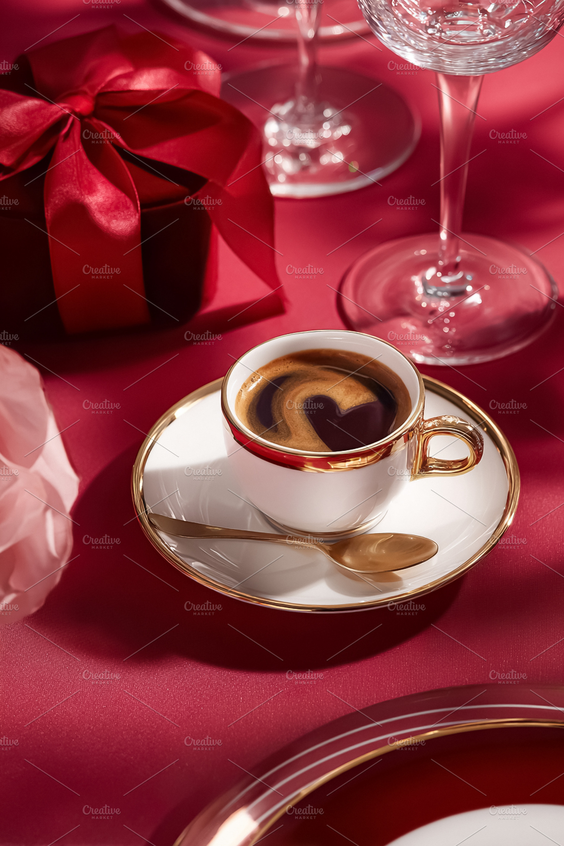 Coffee cup with a heart in its foam, gift box, and crystal glass, a Photo by Studio ANNA