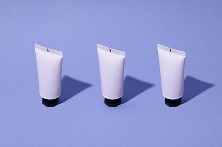 Blank tube of cosmetic on violet background, space for text, a Beauty & Fashion Photo by AtlasStudio PRO