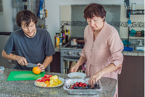 Older woman cooking lunch together, a Person Photo by Elizaveta Galitskaya