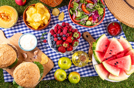 Tasty summer barbecue table with hamburgers, salads, fruits and
