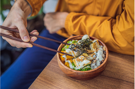 Man eating Raw Organic Poke Bowl, a Food & Drink Photo by Elizaveta Galitskaya