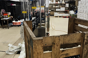 Industrial warehouse with stocked shelves and machinery for bottle packaging, a Photo by AS photostudio