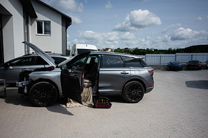 Modern silver car under repair outdoors with tools and open hood, a Transportation Photo by AS photostudio