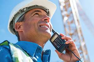 Construction worker communicating at a job site, a Business Photo by AlyaAnd