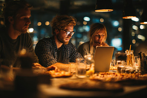 Young adults using laptop late night, a Photo by Pixeness Studio