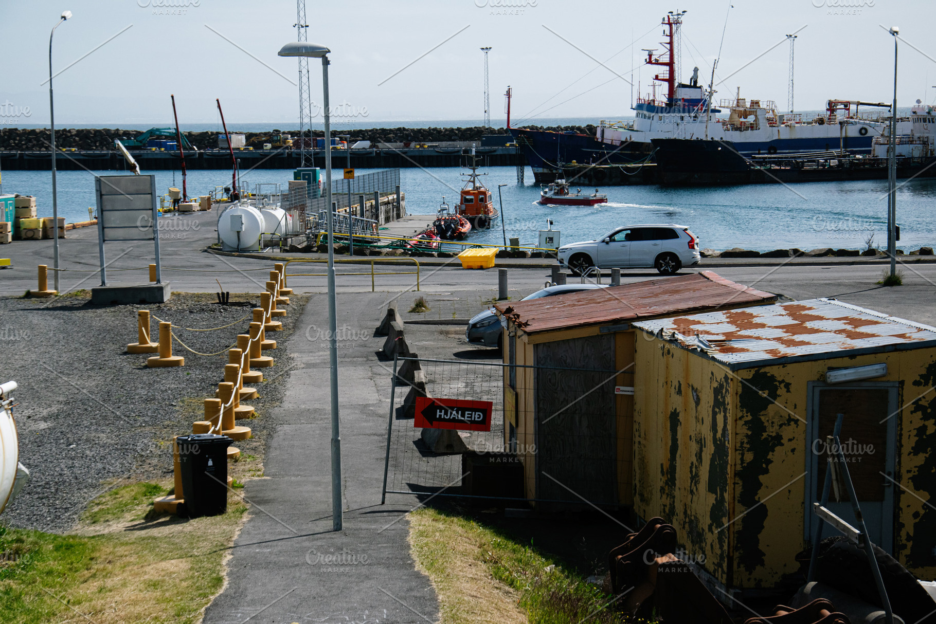 Seaside harbor view with industrial equipment and boats in Akranes, Iceland, a Photo by AS photostudio
