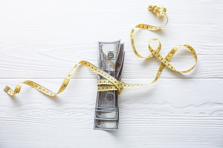 Dollars money with a tape measure containing american, australian, and