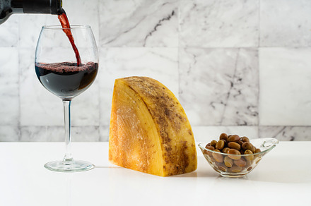 a piece of parmesan or pecorino cheese on a white table and red, a Food & Drink Photo by IriGri