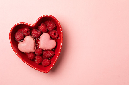 Romantic setup: heart shaped macarons and raspberries in a heart