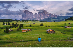 Hiker standing in a green meadow, a Nature Photo by den-belitsky