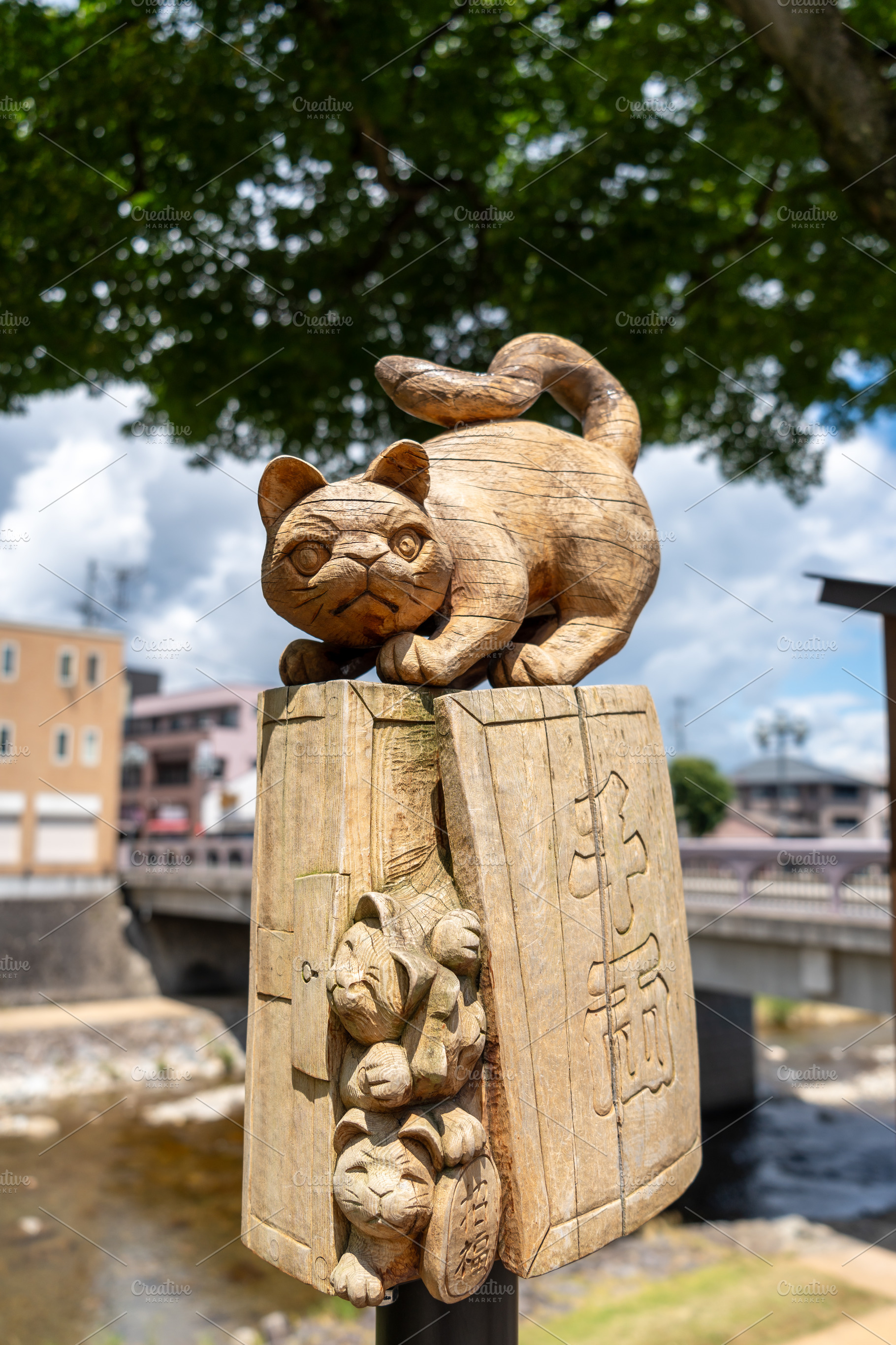 Wooden cat statue by Miyagawa River in Takayama, Japan, an Architecture Photo by GoodGoods