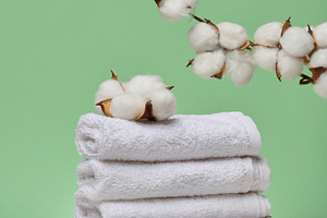 A stack of white folded towels lies on a marble stand, with natu, a Beauty & Fashion Photo by ndanko