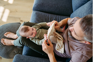 Top view of father holding baby boy, a Person Photo by HalfPoint