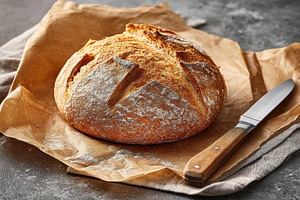 Freshly baked round loaf of bread, a Food & Drink Photo by AlyaAnd
