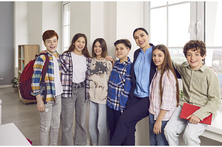 Happy school students standing close