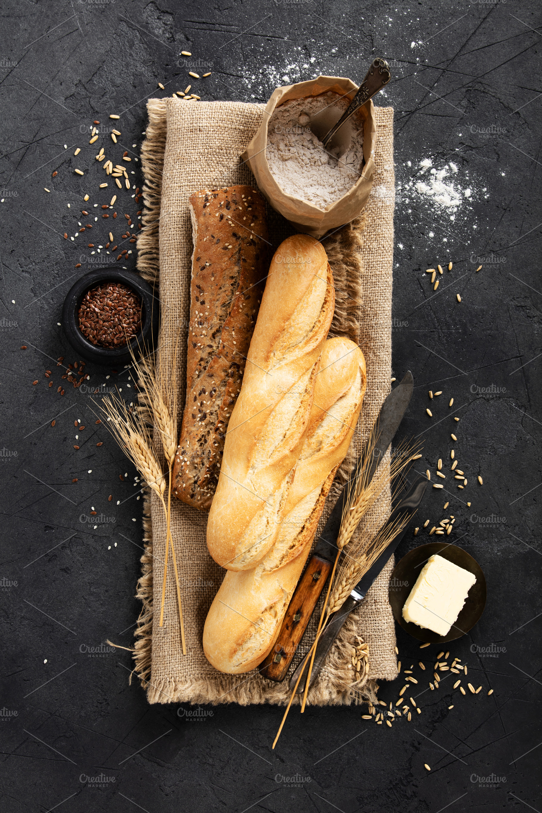 Rustic Baguettes with Flour, Seeds, and Butter on Burlap, a Food & Drink Photo by Natalia Klenova's Shop