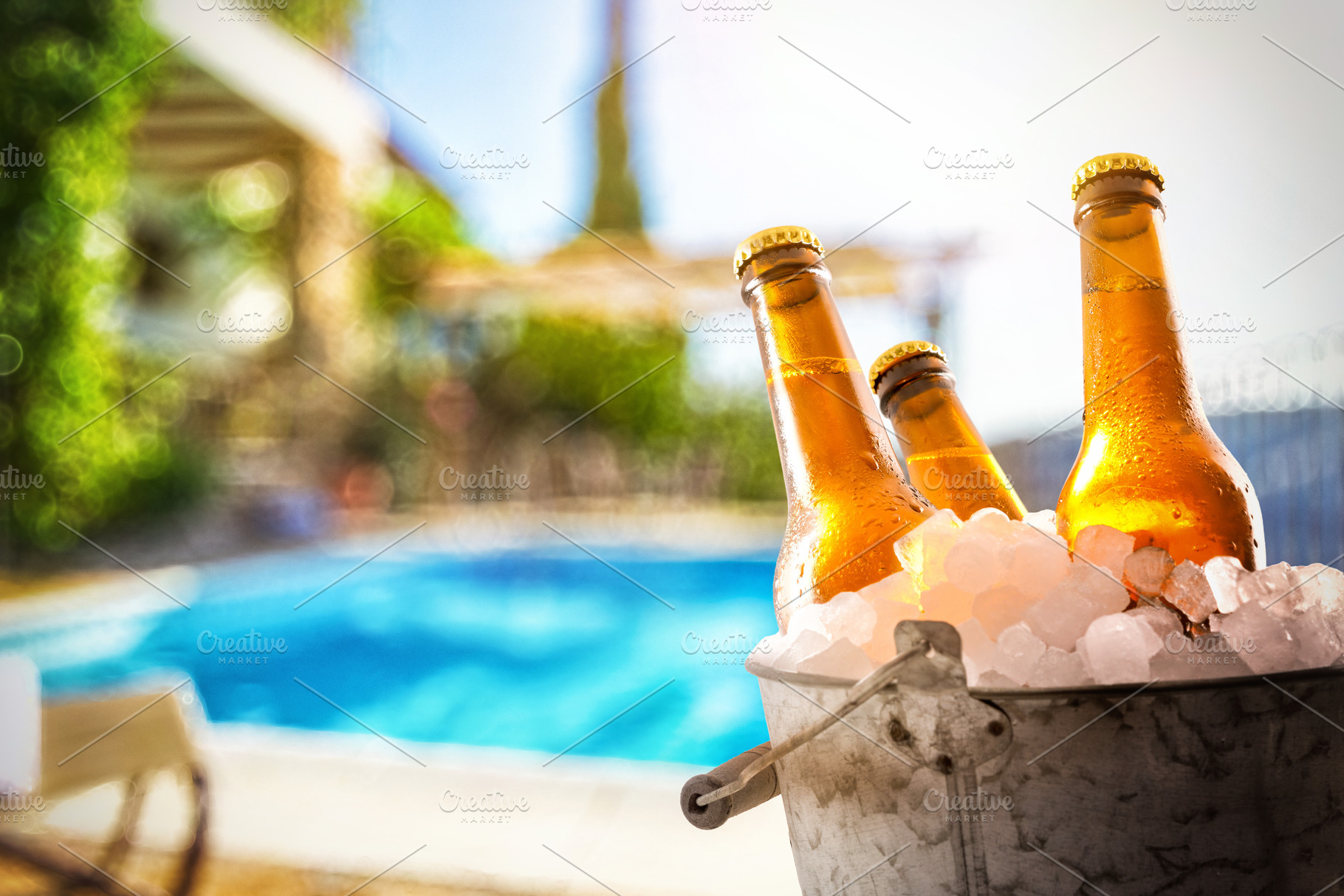 Beers in ice buckets in a garden with a pool, a Food & Drink Photo by Davizro's Market