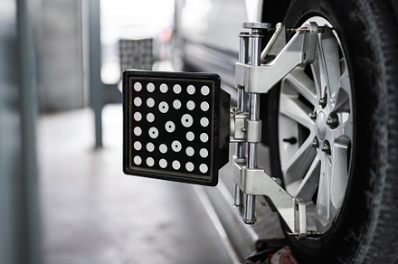 Car wheel alignment with specialized equipment in auto repair shop, a Transportation Photo by AS photostudio