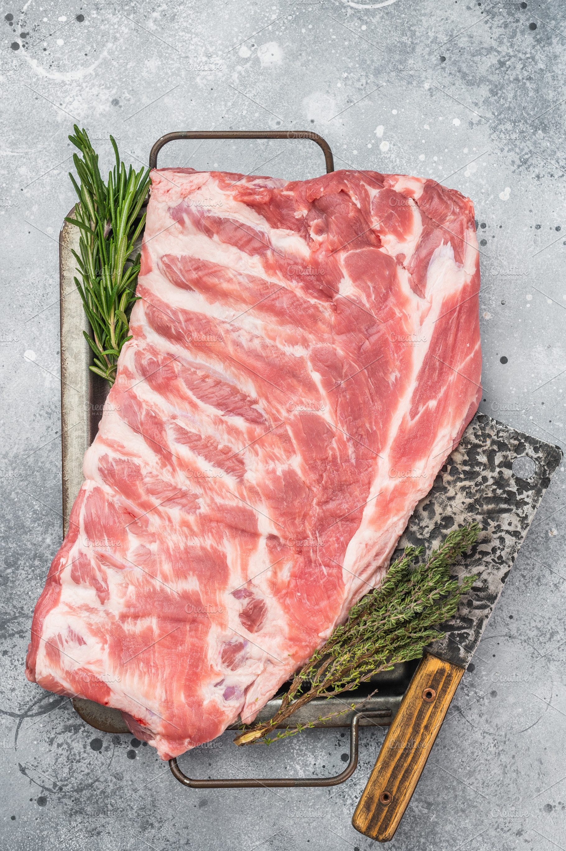 Raw pork spareribs slab on metal tray with herbs and knife flat, a Food & Drink Photo by composter-box@mail.ru