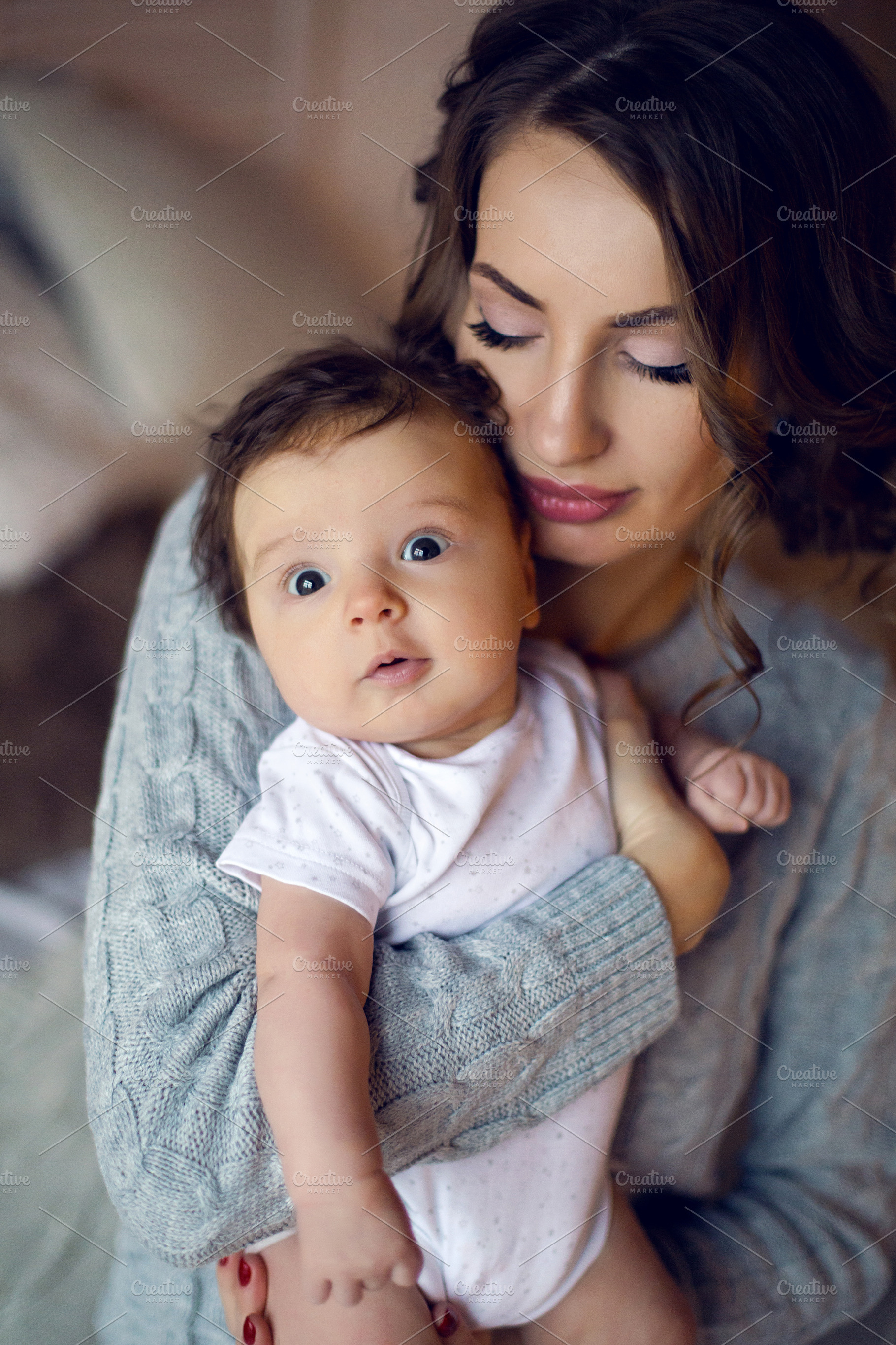 Mom in a sweater holding in his hand containing baby, mother, and son, a Person Photo by SaulichPhoto
